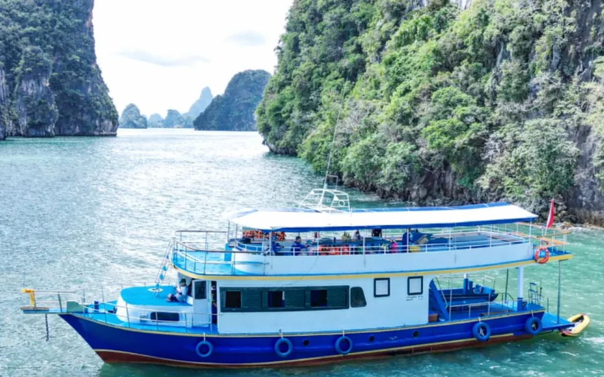 A speedboat under way on open water between Phuket and the limestone coast of Krabi