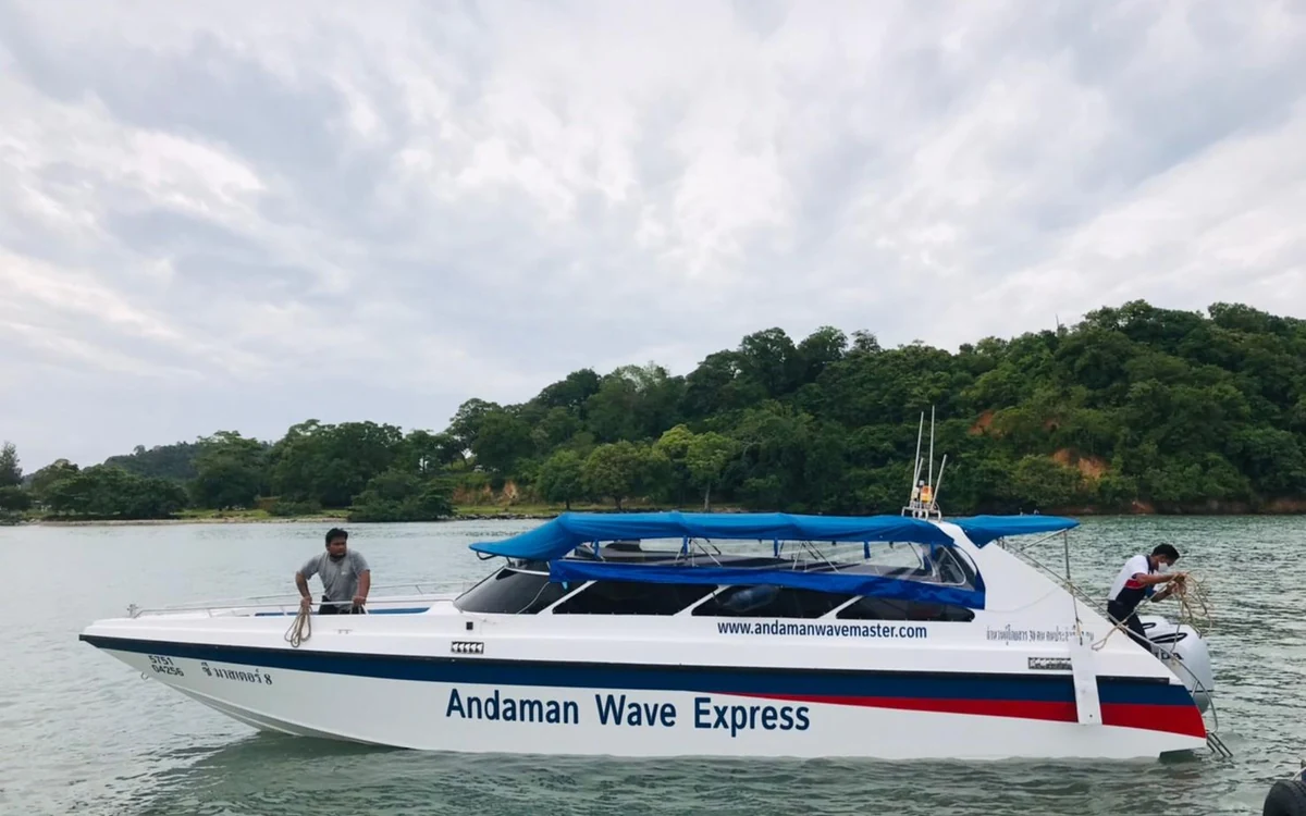 A speedboat under way on flat morning water between Phuket and the Krabi coast