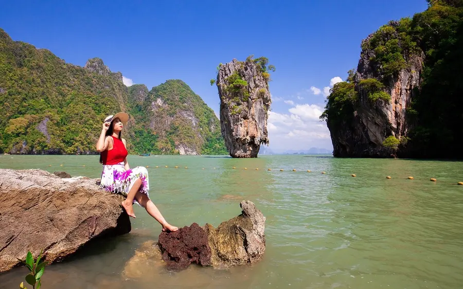 Limestone karsts standing in the green water of Phang Nga Bay