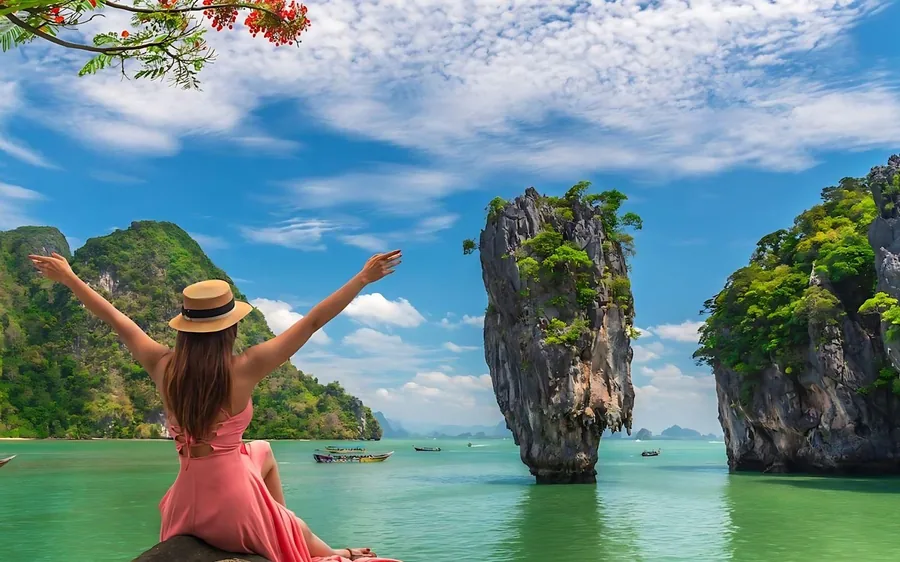 A sea canoe entering a cave under a limestone cliff